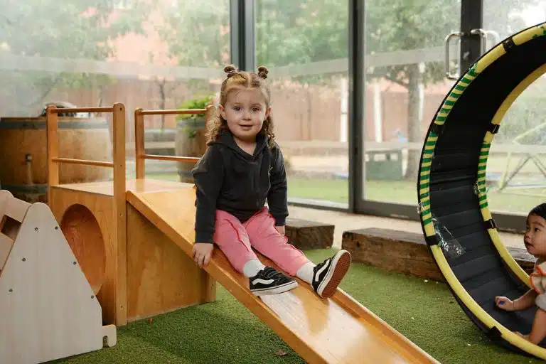 Evoke Clayton. Image of little girl in pink trousers on slide
